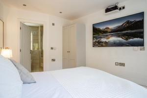 a bedroom with a white bed and a painting on the wall at York Cottage in Whitby
