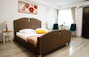 een slaapkamer met een groot bed en 2 stoelen bij Casa Alis in Oradea