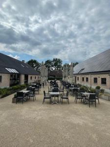 un gruppo di tavoli e sedie in un cortile di Bouwelhoeve 't Schuur a Grobbendonk