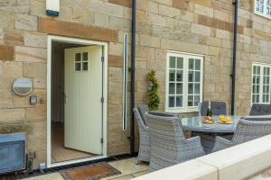 a patio with a table and chairs and a tv at York Cottage in Whitby