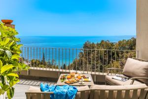 Un balcón con una mesa con fruta. en Belduomo, en Taormina