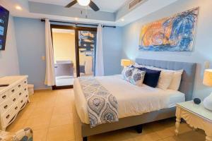 a blue bedroom with a bed and a painting on the wall at Stylish 3-BR Vacation Condo with Scenic Rooftop in Jacó +24 photos