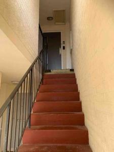 uma escada num edifício com escadas vermelhas em Cosy 1st floor 2 bedroom flat em Little Paxton