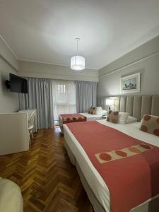 Habitación de hotel con 2 camas y TV en Hotel Facon Grande en Buenos Aires
