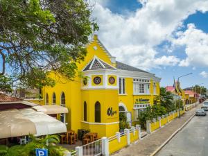 a yellow building on the side of a street at Boutique Hotel 't Klooster in Willemstad