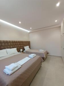 1 dormitorio con 2 camas y toallas. en Achilles Apartments, en Sarandë