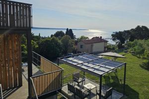 a house with a glass roof with a view of the water at Roma in Portorož