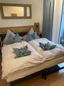 a bed with two flowers on top of it at Alpha Alpin Apartment in Zell am See