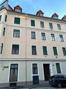 a large building with windows and a car parked in front at Urban Apartment for Erasmus Student, Zentrum in Graz