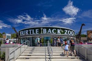a group of people standing in front of a turtle back zoo at Cozy Stylish retreat - NYC & NWK w free parking in Bayonne +16 photos
