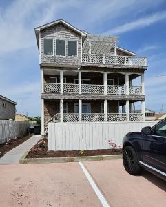 a house with a car parked in front of it at Beach Road Bed and Breakfast in Kill Devil Hills