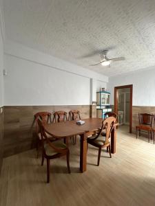Un comedor con mesa y sillas de madera. en Casa Adra, en Adra