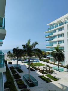 een uitzicht op een resort met palmbomen en een gebouw bij Cartagena primera línea de playa azul vista al mar 2 in Cartagena