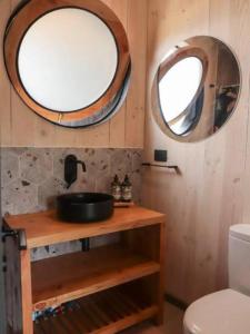 a bathroom with a sink and a round mirror at Casa MacaFelipe in Pichilemu +21 photos