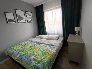 um pequeno quarto com uma cama e uma janela em Apartament Siedlce em Siedlce