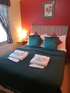 1 dormitorio con 1 cama con toallas en Cosy Woodlands Lodge with Hot Tub, Decking & Garden, en Beattock