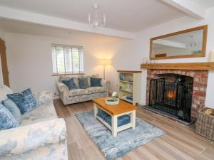 a living room with a couch and a fireplace at 2 Penporth in Rhayader