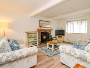 a living room with two couches and a fireplace at 2 Penporth in Rhayader