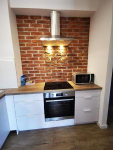 uma cozinha com um micro-ondas e uma parede de tijolos em Apartament Siedlce em Siedlce
