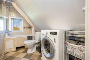 Un baño con lavadora y un inodoro. en Willow studio apartment in Klaipeda Oldtown, en Klaipėda
