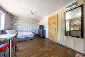 Habitación pequeña con cama, mesa y cocina en Willow studio apartment in Klaipeda Oldtown, en Klaipėda