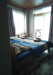 a bedroom with two beds and a large window at Mountain Dream House in Gudauri