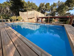 una gran piscina con terraza de madera en villa dei cento Pini en Monteroni di Lecce