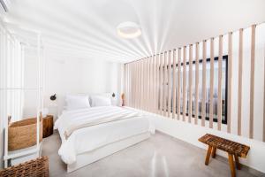 a white bedroom with a bed and a window at serene villas halkidiki - Cfront private pool in Epanomi