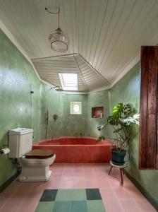 uma casa de banho com uma banheira vermelha e um WC. em Casa da Encosta - Hillside cabin near the sea em Colares