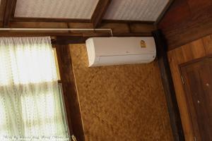 eine Klimaanlage in einem Zimmer mit Fenster in der Unterkunft Saranghae Home Chiang Dao in Ban Tham