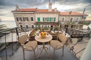 佩特罗瓦纳莫鲁Marco Polo的带桌椅的阳台和一栋建筑