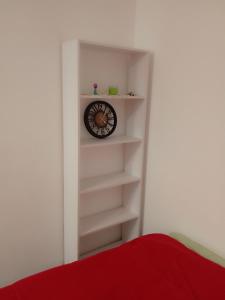 a book shelf with a clock on a wall at Апартамент в Новобудові Стрийська Автовокзал in Lviv