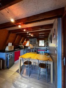 kuchnia z żółtym stołem i krzesłami w obiekcie Chalet de montagne w mieście Ustou