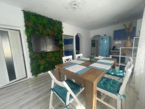 a dining room with a wooden table and chairs at CASA ELLA in Murighiol