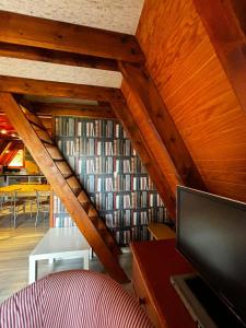 Pokój ze schodami z półką na książki wypełnioną książkami w obiekcie Chalet de montagne w mieście Ustou