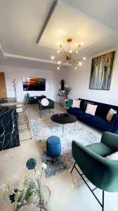 sala de estar con sofá azul y sillas en Luxueux appartement entre Gueliz et l'Hivernage avec WIFI en Marrakech