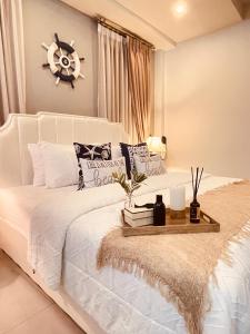 ein Schlafzimmer mit einem weißen Bett mit einer Uhr an der Wand in der Unterkunft Romlaphass Boutique hotel in Kalasin