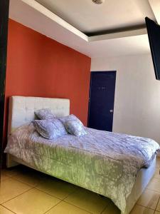 a bed in a room with a red wall at Casa Matiza in Santiago Este