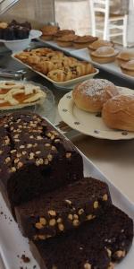uma mesa com diferentes tipos de bolos e pastelarias em pratos em Accogliente Dimora em Putignano