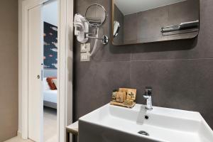 y baño con lavabo blanco y espejo. en Belduomo, en Taormina