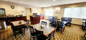 un comedor con mesas y sillas en un restaurante en Park Hill Inn & Suite, en Red Deer