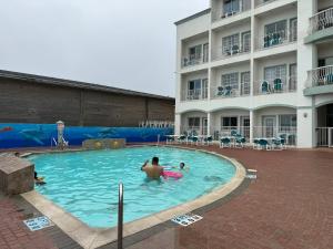 a man in a swimming pool next to a hotel at Sand Rose Beach Resort in South Padre Island