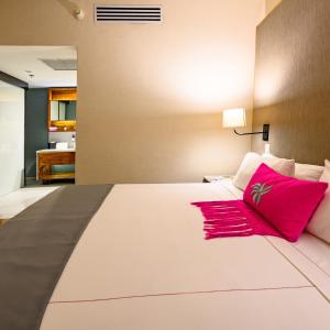 a bedroom with a large white bed with red pillows at Las Suites Campos Eliseos in Mexico City