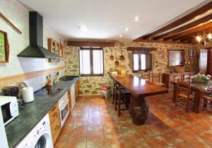 a kitchen with a wooden table and a dining room at CASA RURAL SANDRA in La Carrera