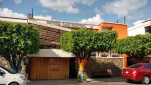 uma mulher sentada num banco em frente a um edifício em San Pietro Boutique Hotel em Guadalajara