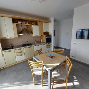 a kitchen with a table and chairs in a room at La Pineta, 26 - 3 in Casarza Ligure