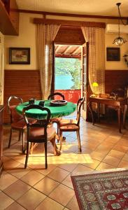 a dining room with a green table and chairs at Villa Andreina Como Lake in Moltrasio +20 photos