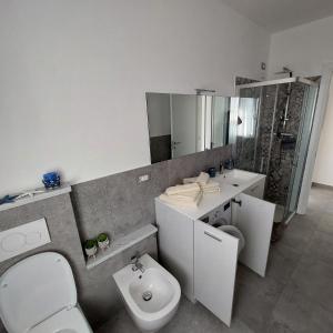 a white bathroom with a toilet and a sink at La Pineta, 26 - 3 in Casarza Ligure
