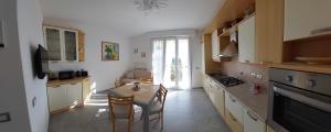 a kitchen with a table and a dining room at La Pineta, 26 - 3 in Casarza Ligure