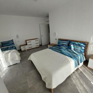 a bedroom with a large bed with blue and white sheets at La Pineta, 26 - 3 in Casarza Ligure